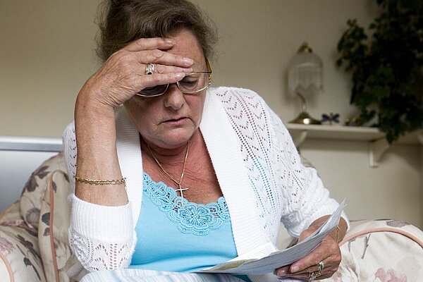 A lady looking at her bills.